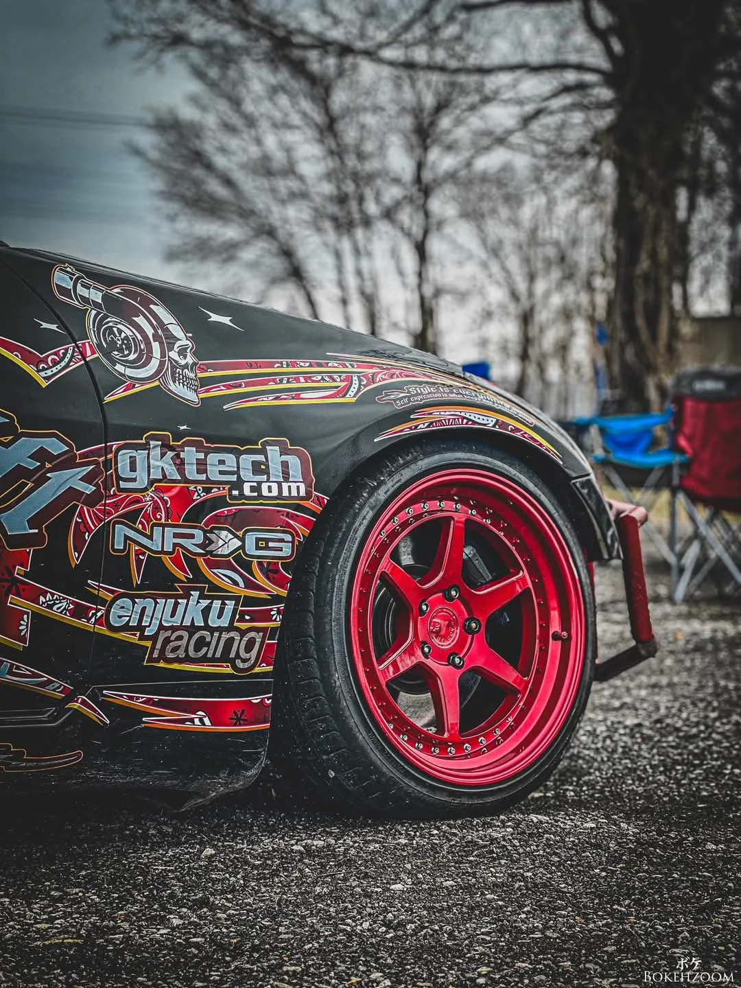 Black Apex Autoworks race car with red wheels on track